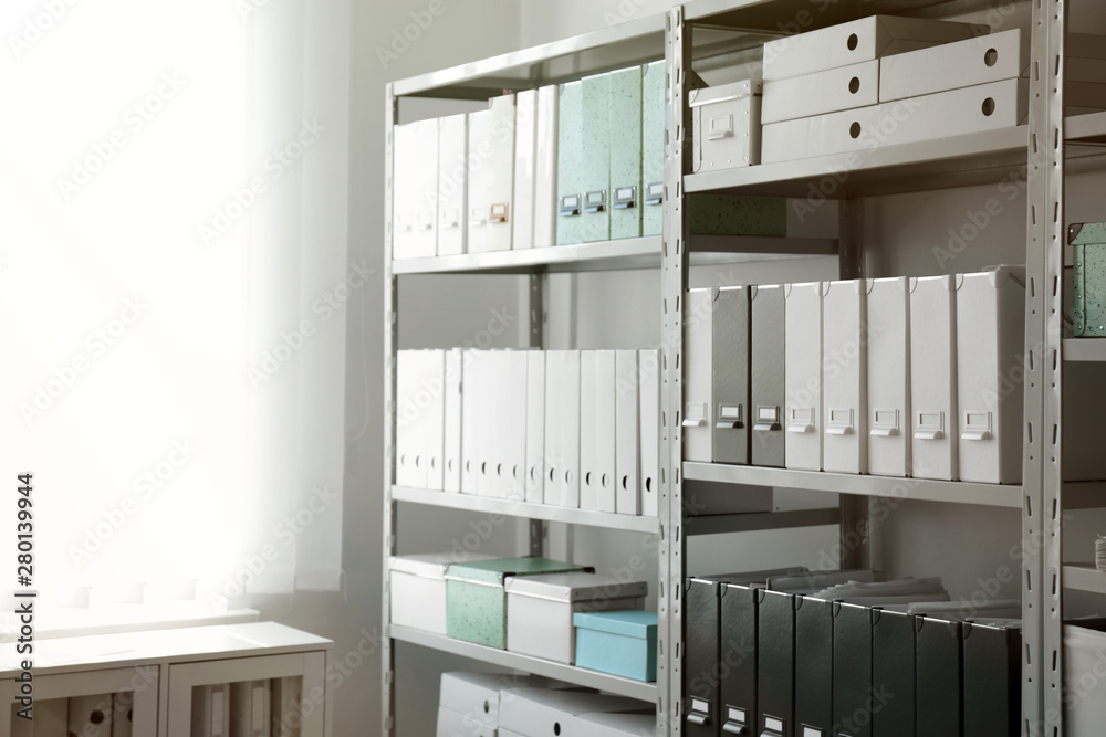 Folders with documents on shelves in archive