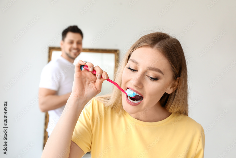 Beautiful woman cleaning teeth at home