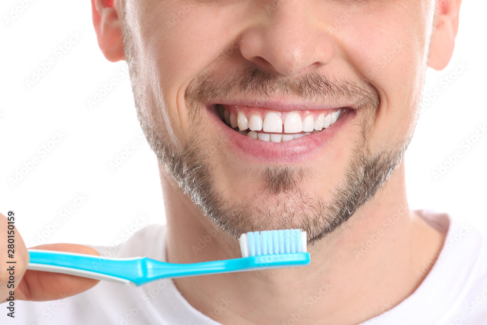 Man cleaning teeth on white background, closeup