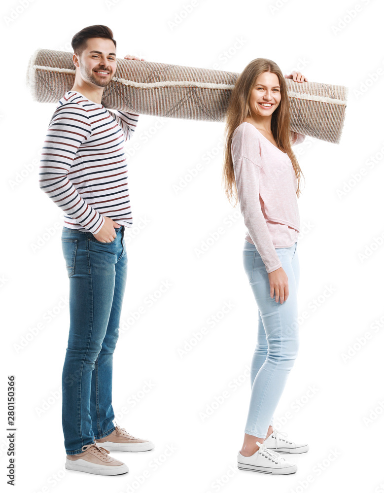 Young couple holding rolled carpet against white background