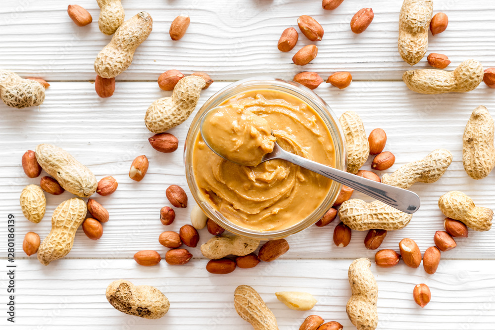 Make peanut butter with paste in glass bowl on white background top view pattern