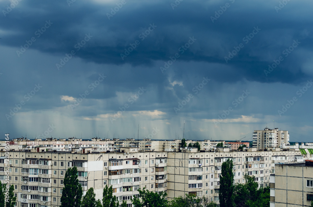 Dark storm clouds over houses, bad weather in the city