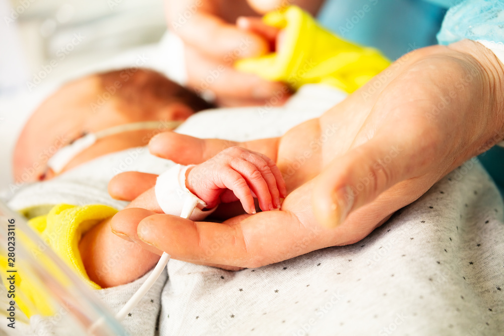 Cool newborn infant child hand and mother fingers