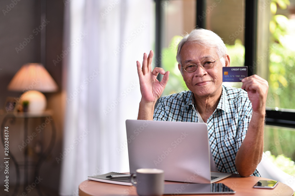 Asian senior man using credit card for online shopping