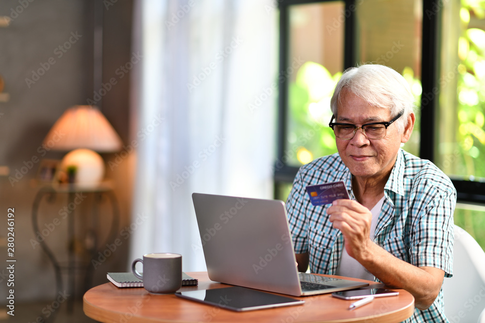 Asian senior man using credit card for online shopping