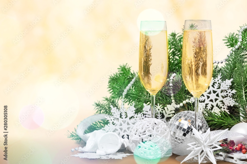 Two Champagne glasses with Christmas decorations and fir tree branch isolated on white