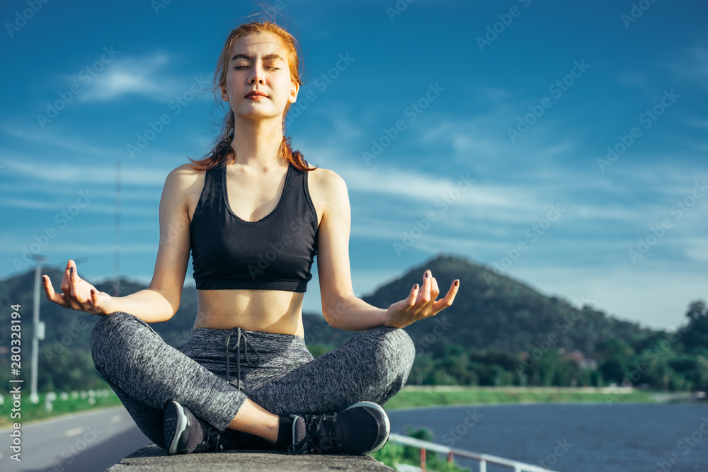 Asian woman is workout and running at the morning, she is warm up her body and playing yoga. Healty 