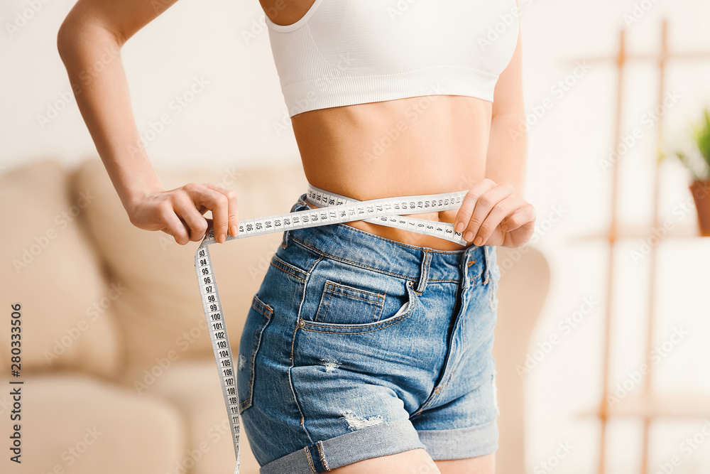 Woman with measuring tape at home. Weight loss concept