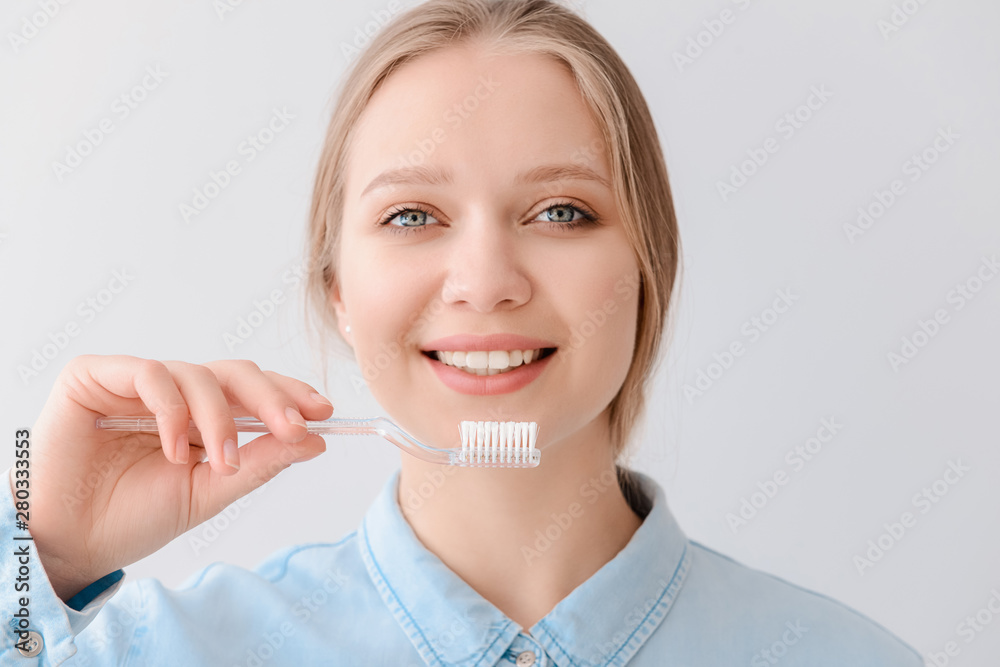 Woman with toothbrush on light background. Concept of dental hygiene