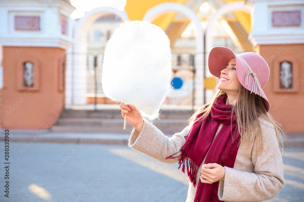 Woman with sweet cotton candy outdoors