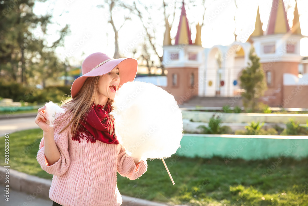 Woman with sweet cotton candy outdoors