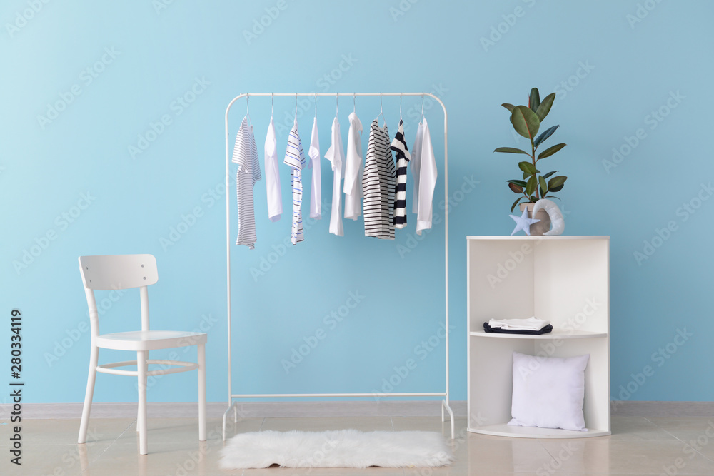 Rack with hanging clothes in interior of dressing room