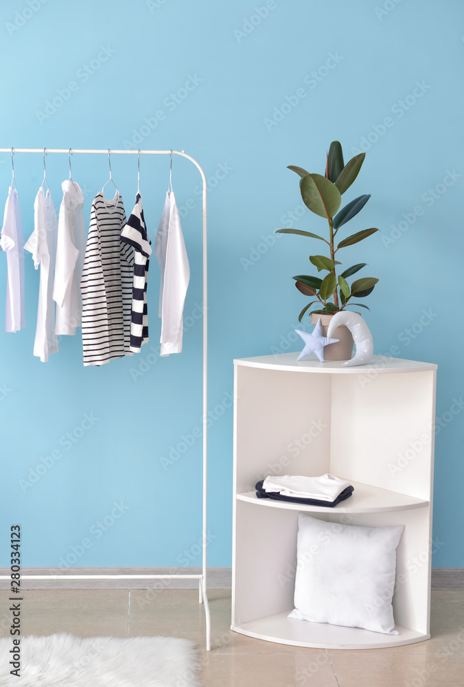 Rack with hanging clothes in interior of dressing room