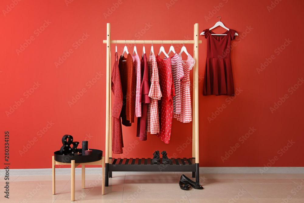 Rack with hanging clothes in interior of dressing room