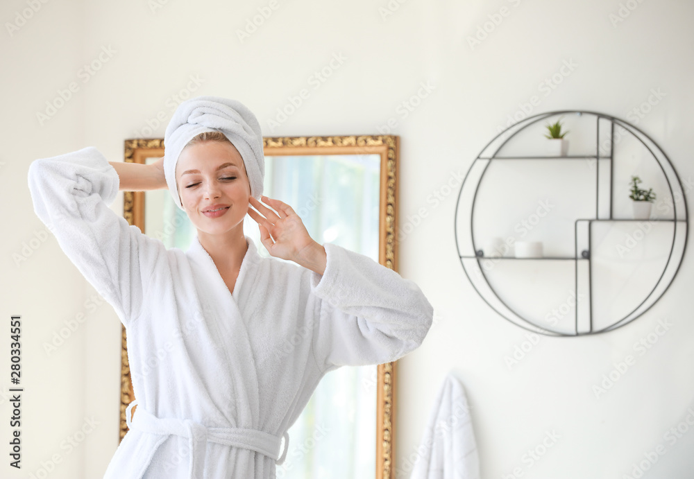 Morning of young woman in bathrobe at home