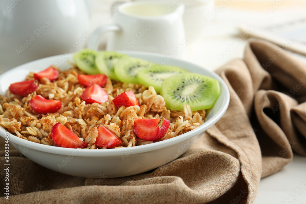 Bowl with tasty sweet oatmeal on table