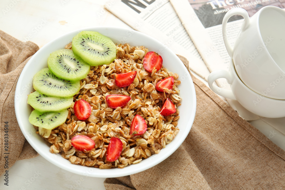 Bowl with tasty sweet oatmeal on table