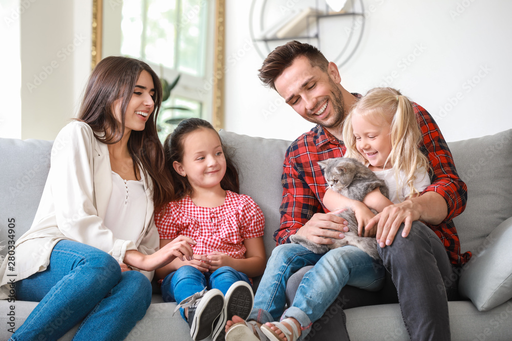 Happy family with cute cat resting at home