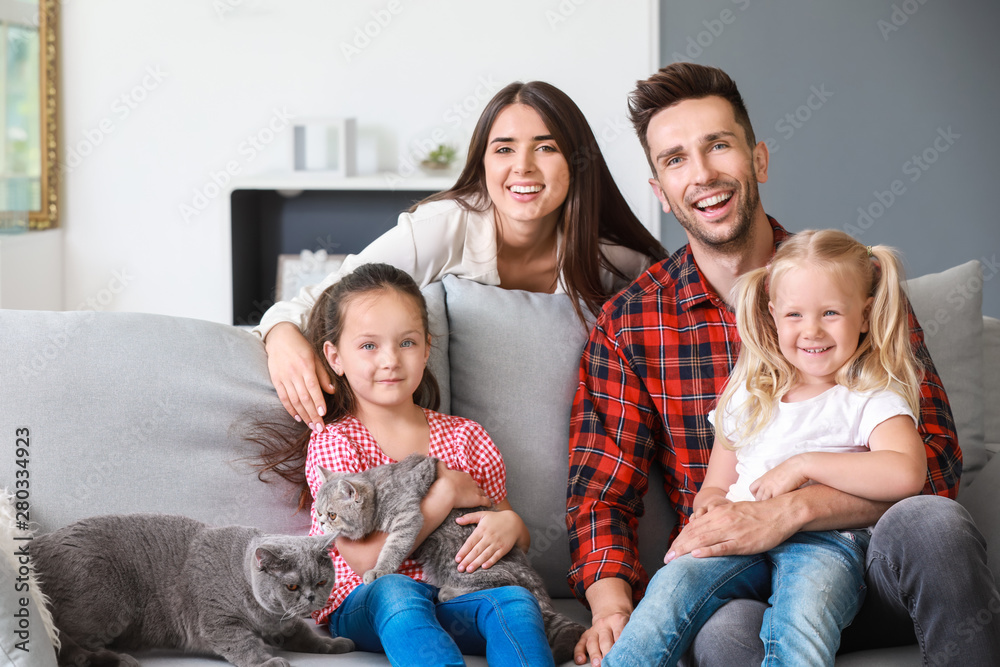 Happy family with cute cats resting at home