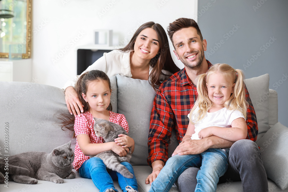 Happy family with cute cats resting at home