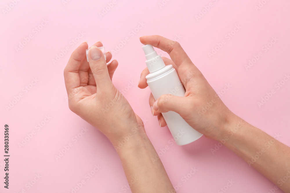 Female hands with cosmetic product on color background