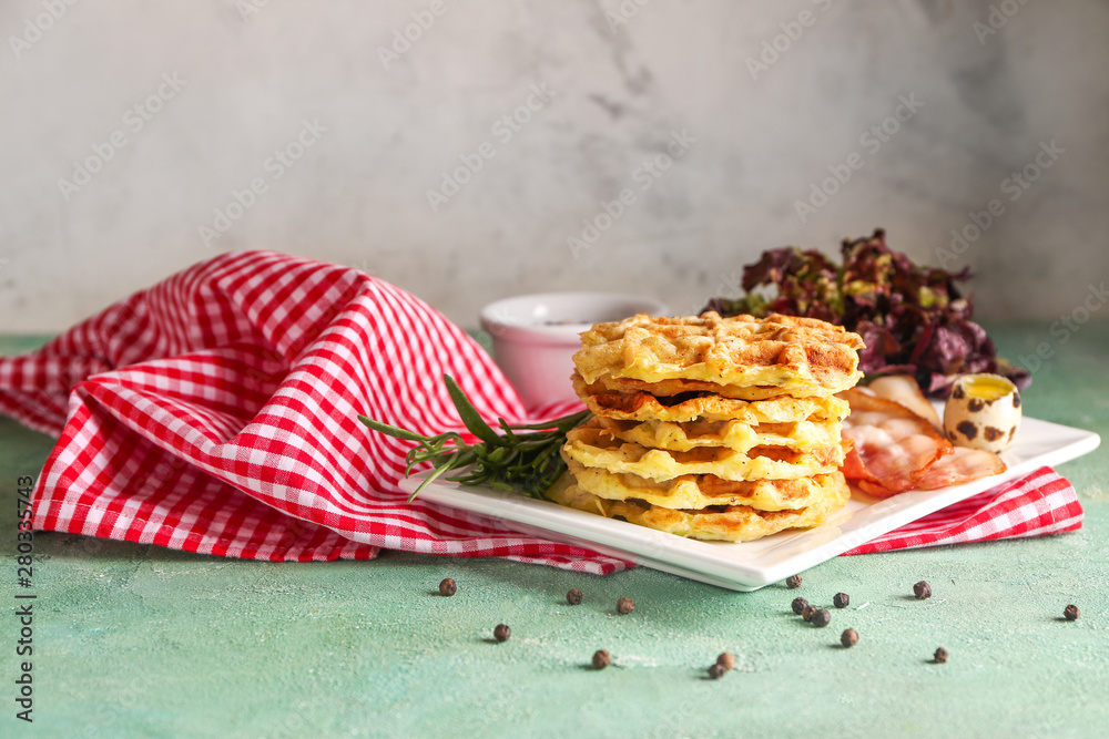 Plate with tasty squash waffles and fried bacon on table