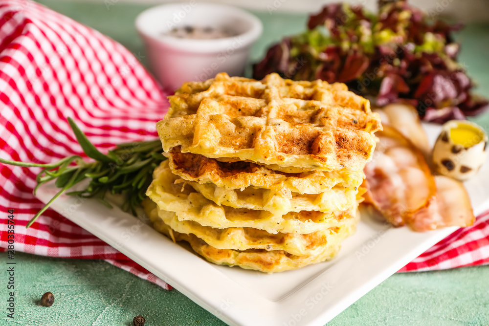 Plate with tasty squash waffles and fried bacon on table, closeup