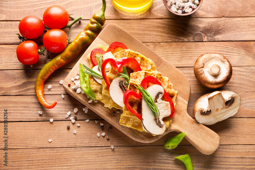 Composition with tasty squash waffles and vegetables on wooden table