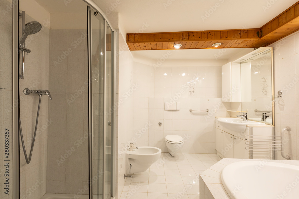 Bathroom with white tiles and wooden ceiling