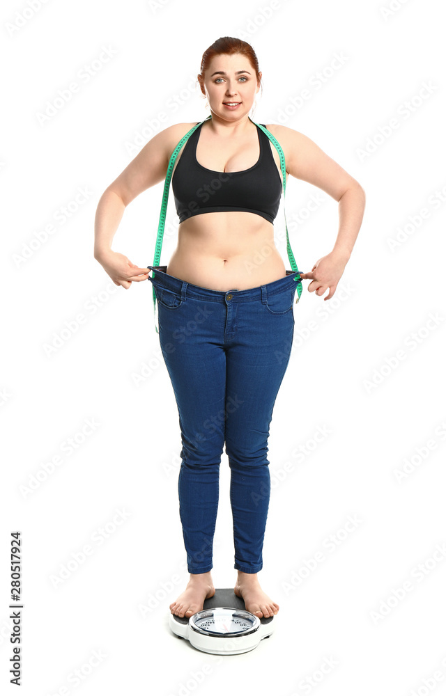 Overweight woman with measuring tape standing on scales against white background. Weight loss concep