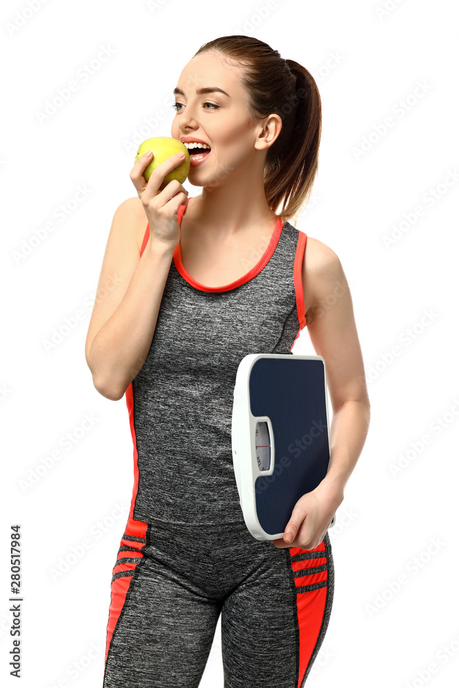 Young woman with apple and scales on white background. Weight loss concept