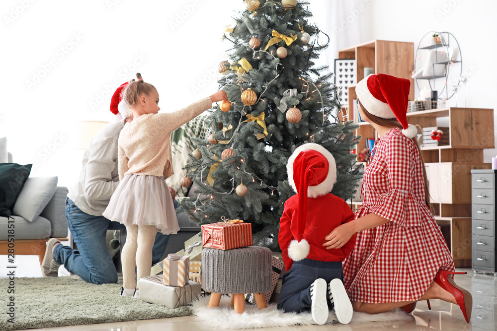 Happy family decorating Christmas tree at home