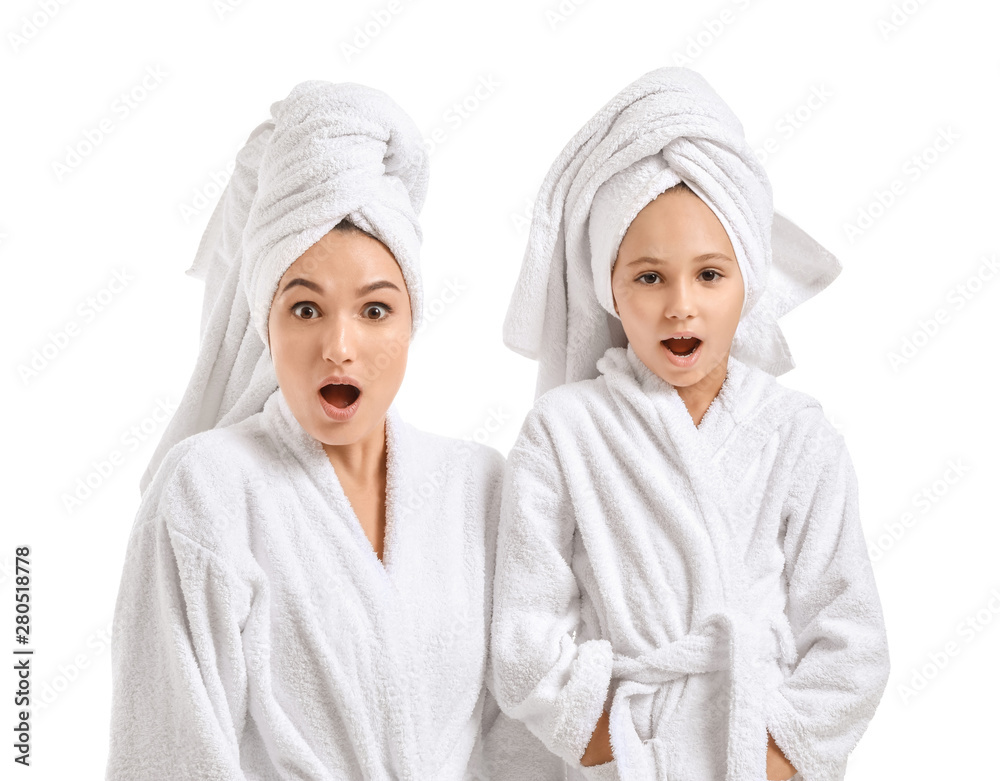 Surprised mother and her little daughter in bathrobes on white background