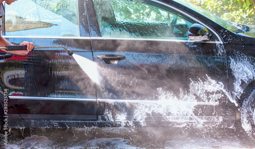 Cleaning black car using high pressure water