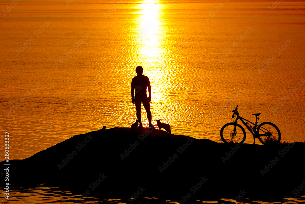 Sporty guy cycling near the river in the evening. Male cyclist riding bike. Healthy active lifestyle