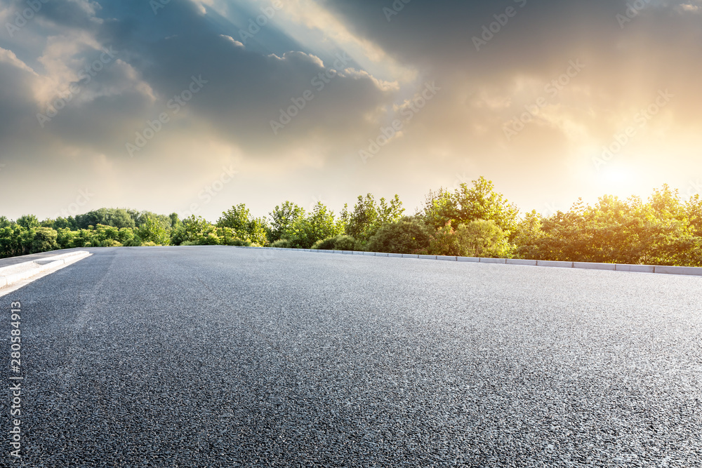 日落时的沥青公路和绿色森林，有美丽的云景观