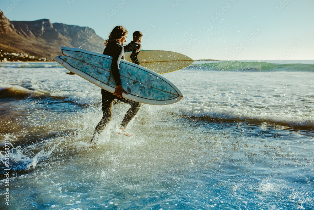 To young surfers going for water surfing