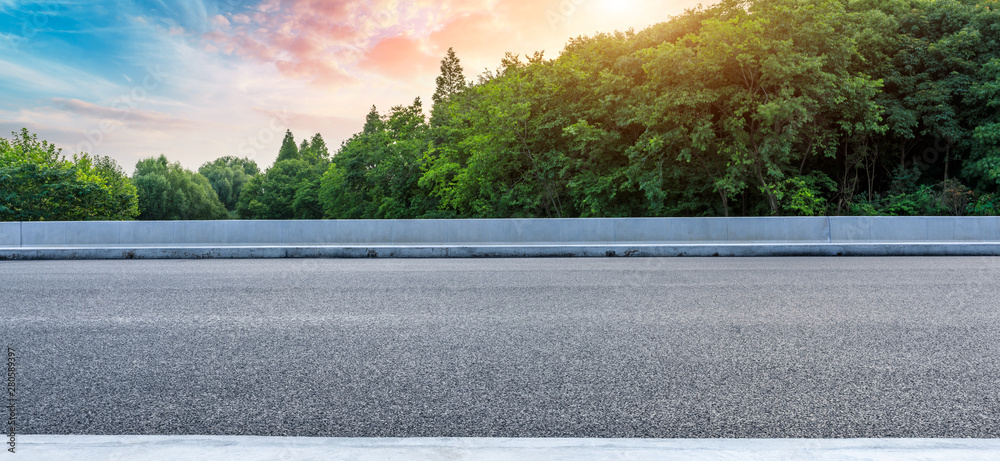 Asphalt highway and green forest with beautiful cloud landscape at sunset