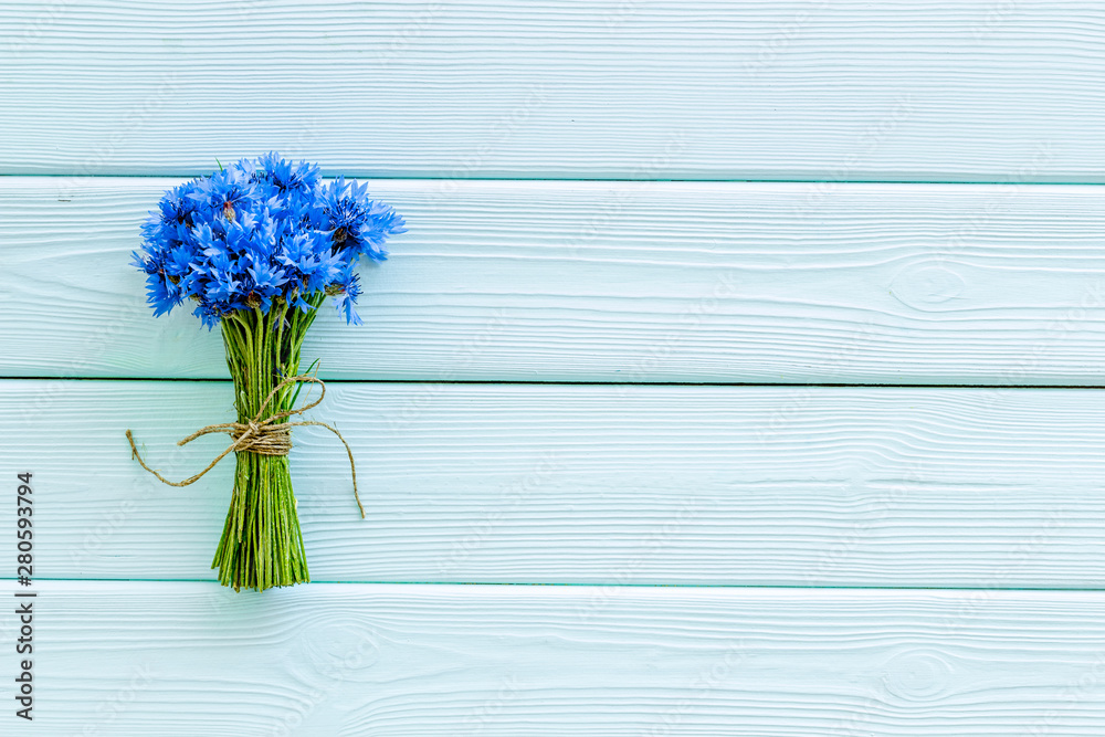 Summer design for blog with bouquet of blue cornflowers on mint green wooden background top view cop