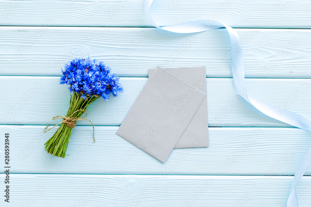 Bouquet of blue cornflowers, envelopes on mint green wooden background top view mockup