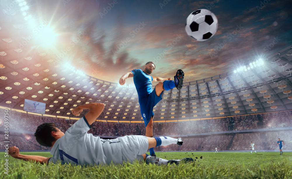 Soccer players in action on professional stadium on sunset.