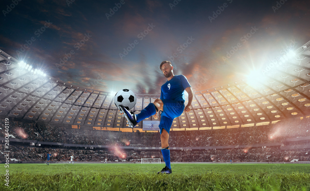 Soccer players in action on professional stadium on sunset.