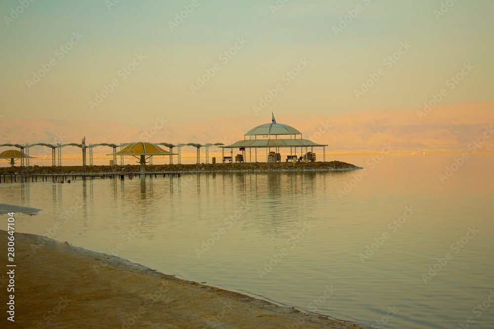 阳光明媚的日子里，海岸上棕榈树环绕的沙滩风景如画