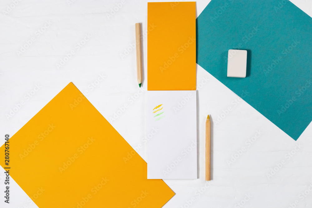 Open notepad with yellow paper cover and wooden pencil for drawing or sketching, eraser on white des