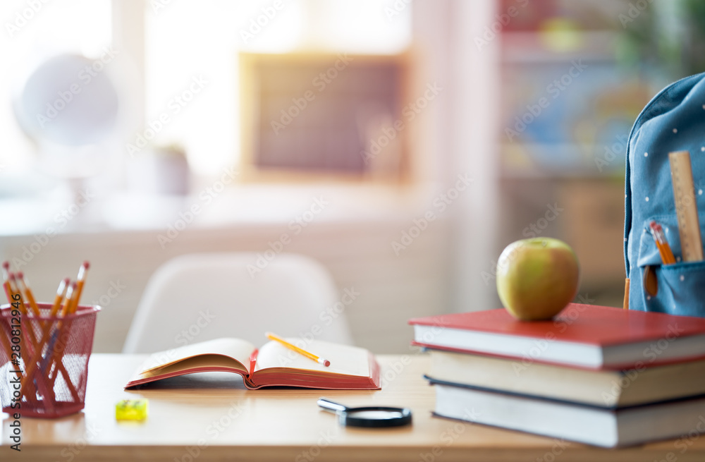 Apple, pile of books and backpack