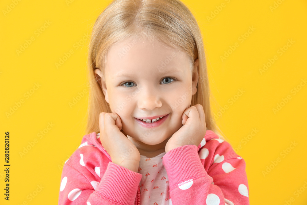 Portrait of adorable little girl on color background