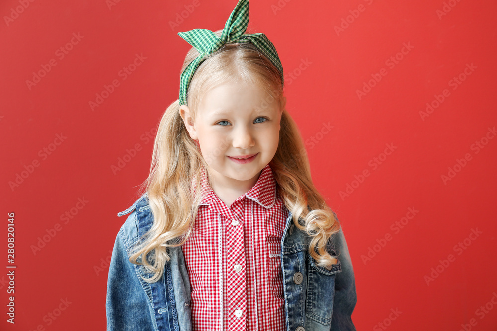 Portrait of stylish little girl on color background