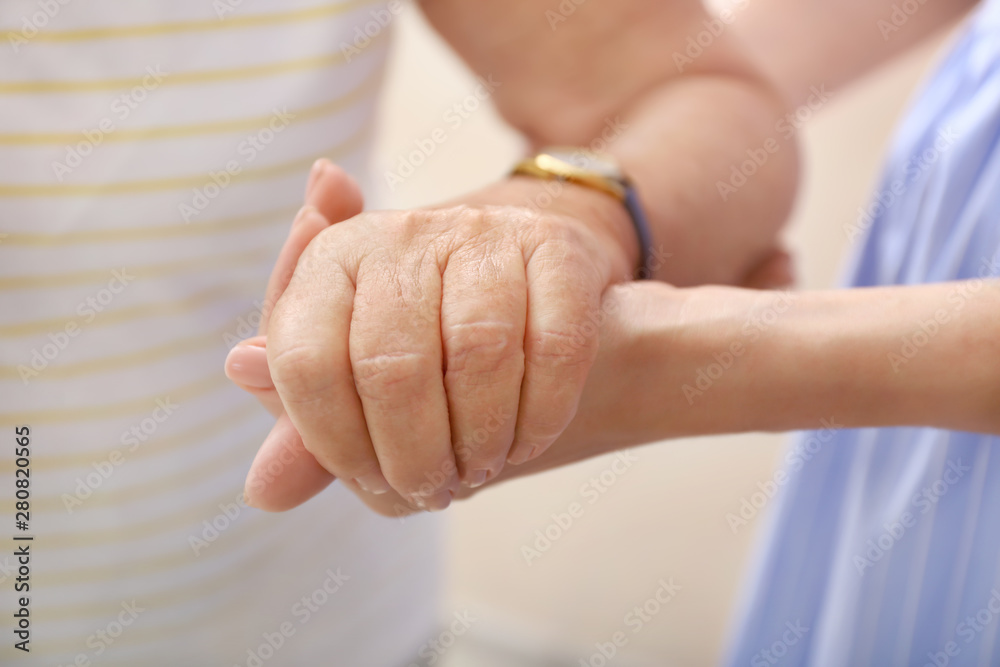 Young daughter calming elderly mother, closeup