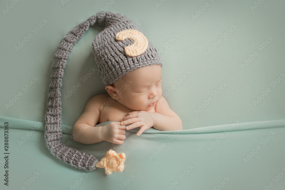 Adorable newborn baby sleeping in cozy room. Cute happy infant baby portrait with sleepy face in bed