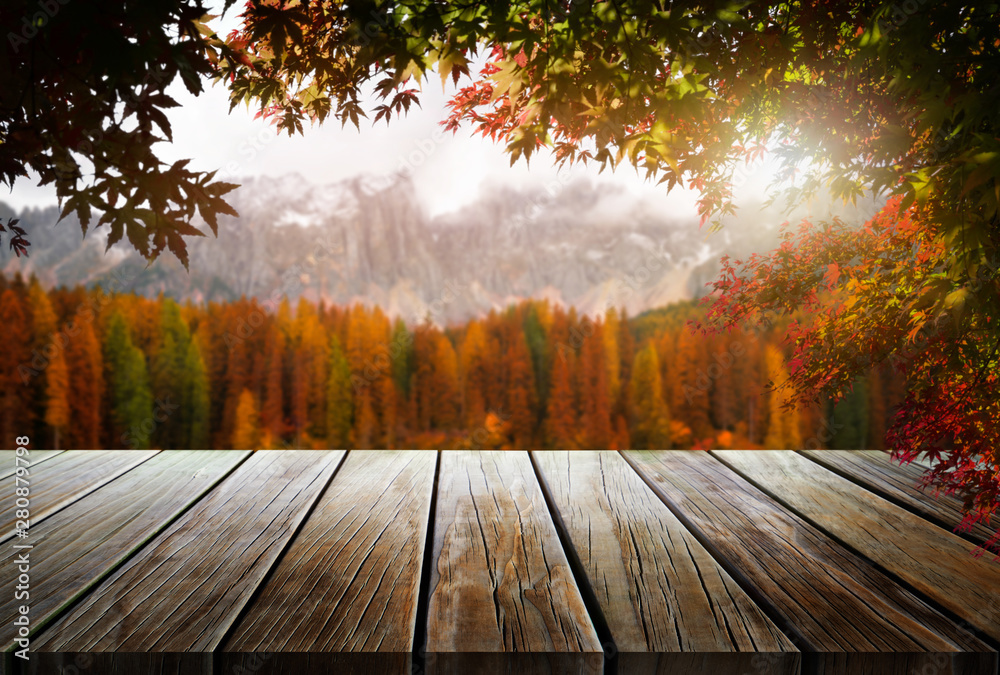 Wood table in autumn landscape with empty copy space for product display.